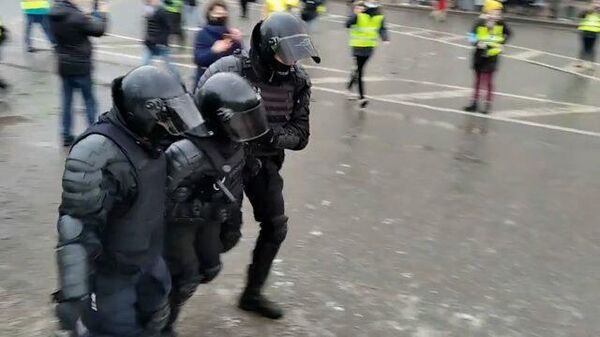 Пострадавшего полицейского выводят с площади в Петербурге 