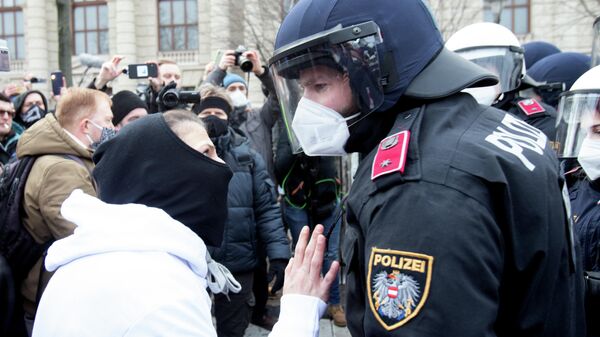 Протестующий и полицейский во время демонстрации в Вене