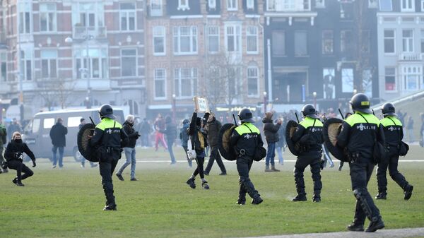 Сотрудники полиции во время акции протеста против ограничений, введенных для сдерживания распространения COVID-19 в Амстердаме