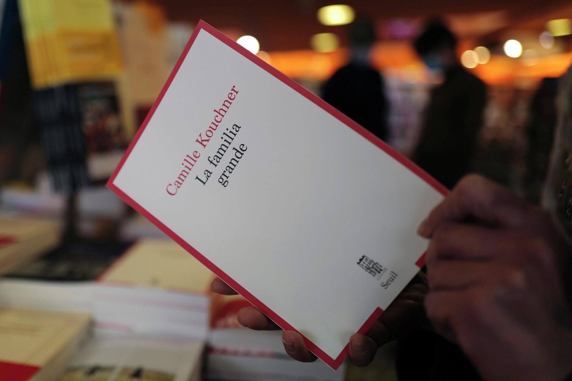 Человек держит книгу Камиллы Кушнер La Familia Grande в книжном магазине Парижа - РИА Новости, 1920, 03.02.2021