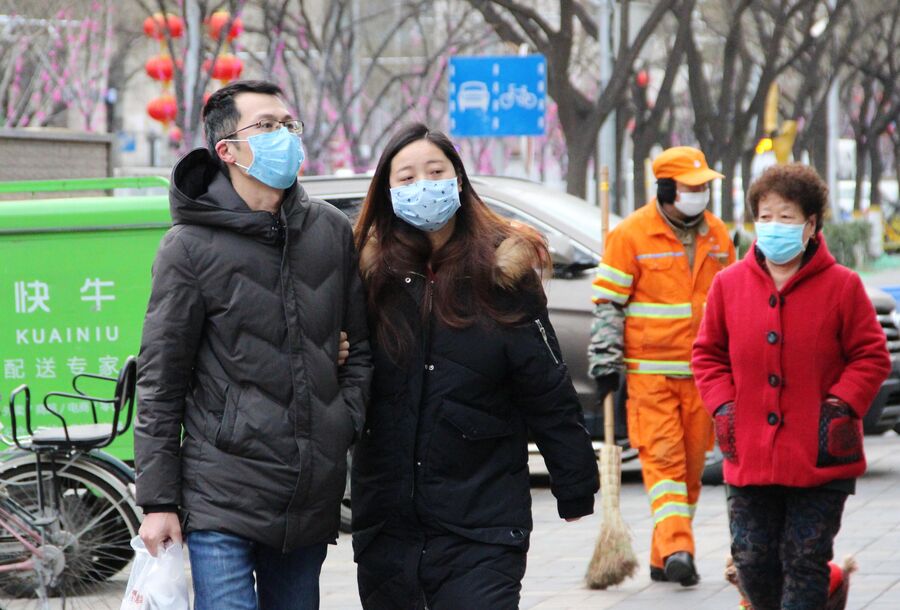 Жители Пекина идут в медицинских масках по улице