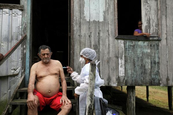 Мужчина прививается от коронавируса вакциной AstraZeneca в Манакапуру, Бразилия 