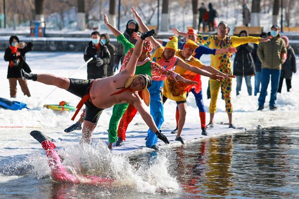 Пловцы прыгают в замерзшее озеро в Шэньяне, в провинции Ляонин на северо-востоке Китая