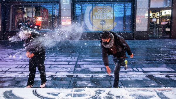 Люди играют в снежки на Таймс-сквер в Нью-Йорке