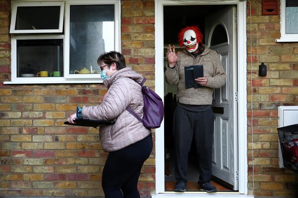 Мужчина в маске Джокера во время пандемии коронавируса в Уокинге, Великобритания 
