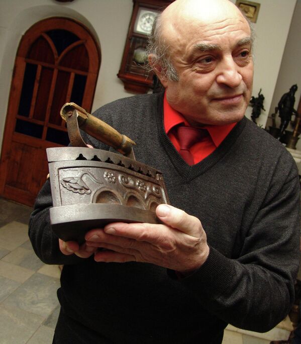 Директор музея Музыка и время Джон Мостославский со старинным утюгом в Ярославле