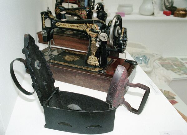 Швейная машина Зингер  и утюг начала XX века на выставке Прощай, XX век в выставочном зале Новый Манеж
