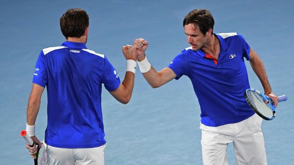 France's Edouard Roger-Vasselin (R) and his partner Nicolas Mahut bump their fists during their ATP Cup group C men's doubles tennis match against Austria's Tristan-Samuel Weissborn and Philipp Oswald in Melbourne on February 5, 2021. (Photo by Paul CROCK / AFP) / -- IMAGE RESTRICTED TO EDITORIAL USE - STRICTLY NO COMMERCIAL USE --