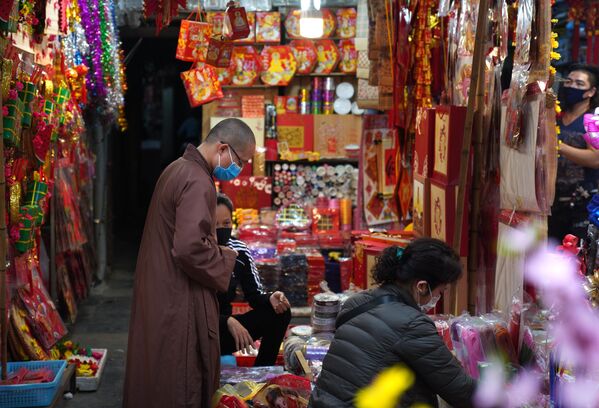 Посетители на рынке новогодних сувениров и украшений для дома на центральной улице Ханоя