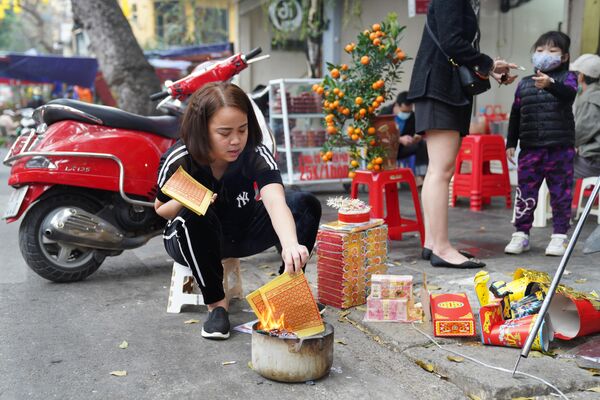 Посетители на рынке новогодних сувениров на центральной улице Ханоя
