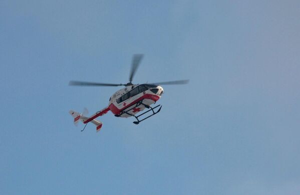 Медицинский вертолет в небе недалеко от места пожара в жилом доме в поселке Мосрентген в Новой Москве