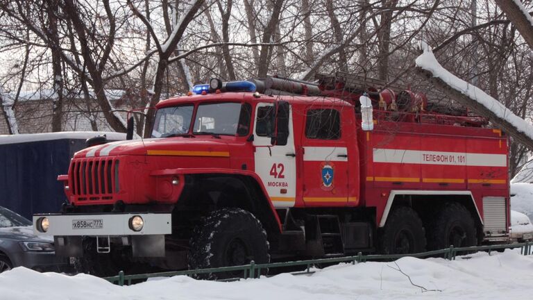 Автомобиль пожарной службы на месте пожара в жилом доме в поселке Мосрентген в Новой Москве