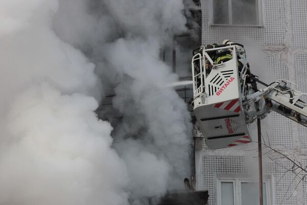 Сотрудники пожарной службы тушат пожар а в жилом доме в поселке Мосрентген в Новой Москве