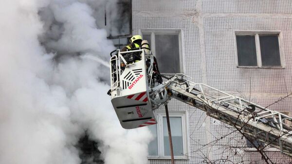 Сотрудники пожарной службы тушат пожар а в жилом доме в поселке Мосрентген в Новой Москве