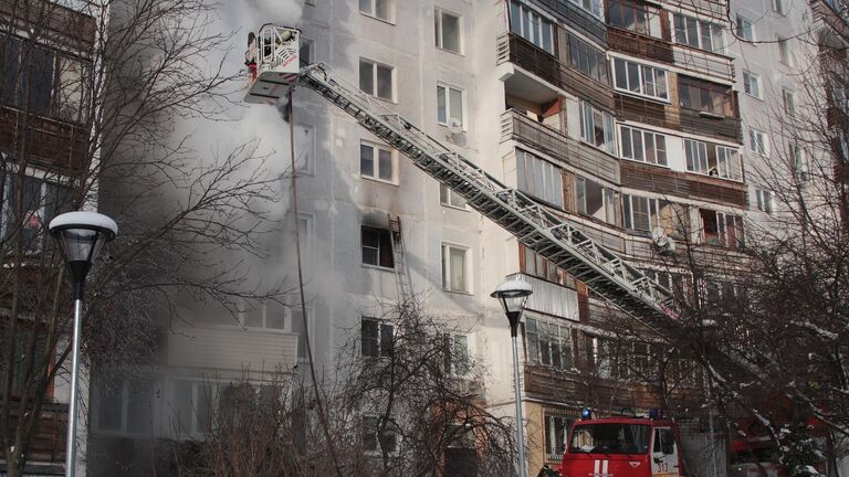 Сотрудники пожарной службы тушат пожар а в жилом доме в поселке Мосрентген в Новой Москве