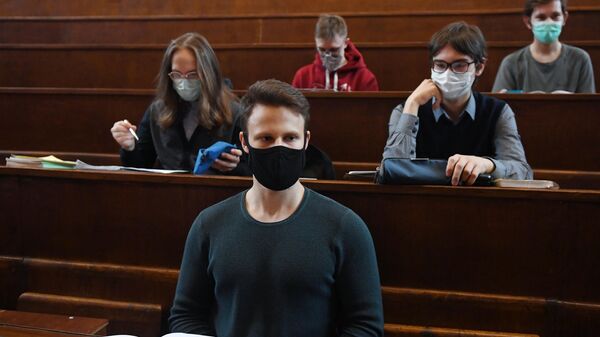 Студенты в защитных масках во время лекции в аудитории Московского государственного университета имени М. В. Ломоносова