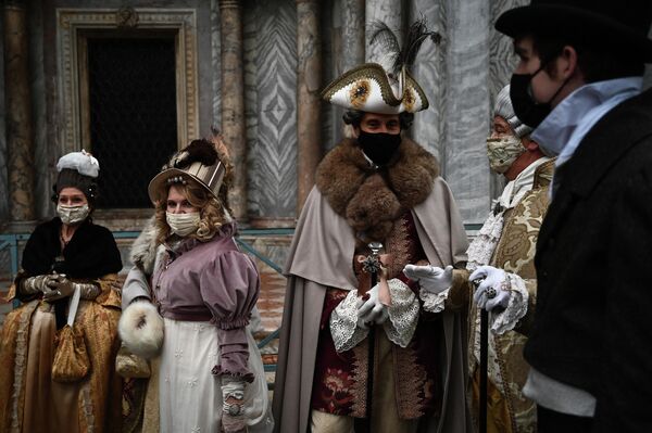 Люди в карнавальных масках и костюмах во время ежегодного Венецианского карнавала, который был отменен в этом году из-за пандемии коронавирусной инфекции в Венеции, Италия