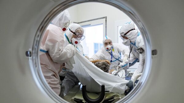 Медики помещают пациента в аппарат компьютерной томографии в городской клинической больнице №40 в Москве
