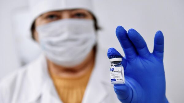 Медицинский работник держит в руке вакцину от COVID-19 Спутник-V (Гам-КОВИД-Вак)