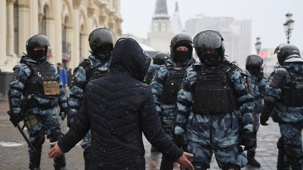Мужчина разговаривает с сотрудниками правоохранительных органов во время несанкционированной акции в Москве