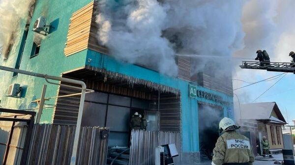 Сотрудники МЧС во время ликвидации пожара на станции техобслуживания в Омске 