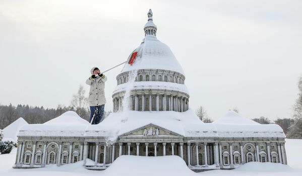 Сотрудник музея убирает снег с Капитолия Вашингтона в Мини-Мире в Лихренштайне, Германия