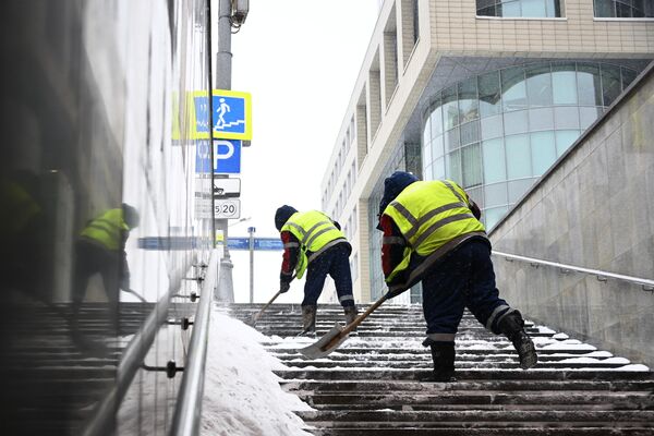 Сотрудники коммунальных служб убирают снег в подземном переходе в Москве