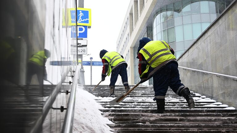 Сотрудники коммунальных служб убирают снег в подземном переходе в Москве