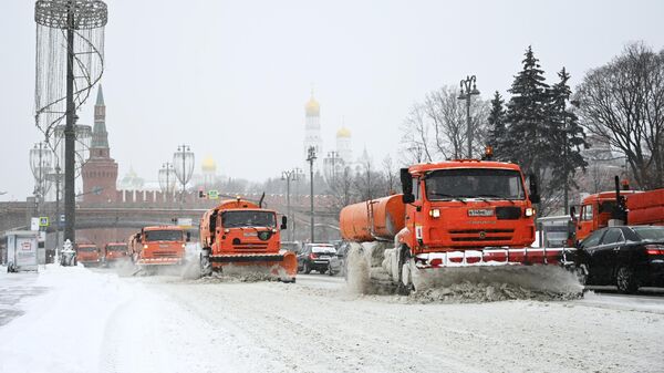 Снегоуборочные машины чистят автомобильную дорогу на Москворецкой набережной в Москве