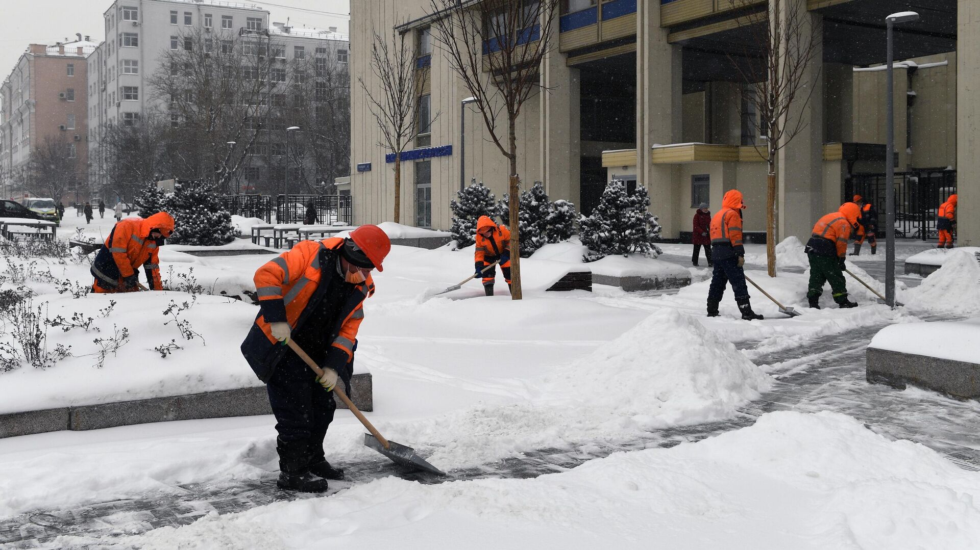 Сотрудники коммунальных служб расчищают тротуар во время снегопада на Зубовском бульваре в Москве - РИА Новости, 1920, 12.02.2021