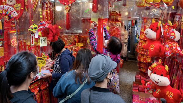 Торговля праздничными декоративными украшениями на уличном рынке во время подготовки к предстоящему Китайскому Новому году в Гонконге