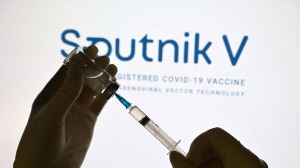 Шприц и ампула на фоне логотипа вакцины Спутник V