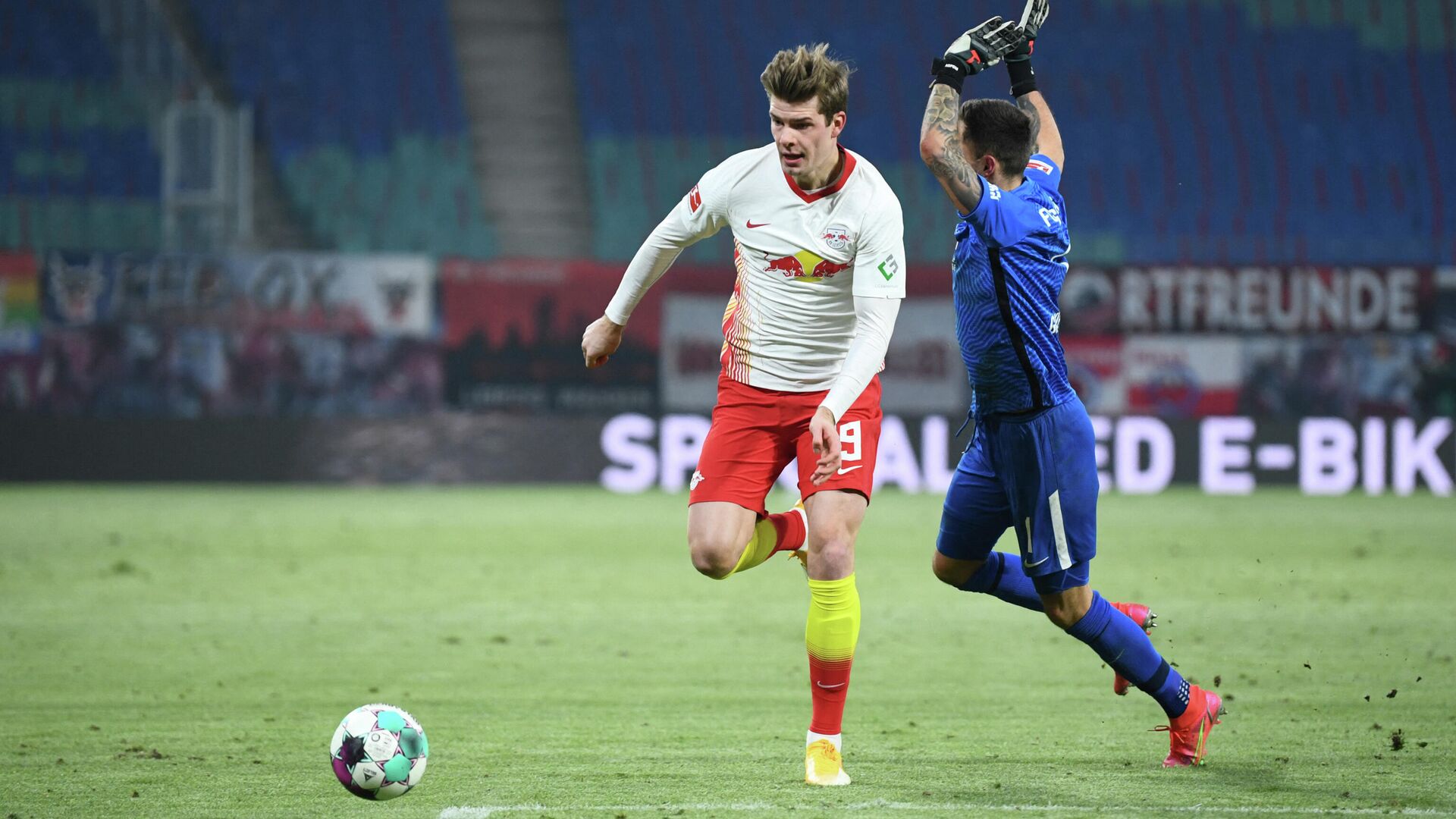 Leipzig's Norwegian forward Alexander Sorloth (L) and Augsburg's Polish goalkeeper Rafal Gikiewicz vie for the ball during the German first division Bundesliga football match between RB Leipzig and FC Augsburg in Leipzig, eastern Germany, on February 12, 2021. (Photo by ANNEGRET HILSE / POOL / AFP) / DFL REGULATIONS PROHIBIT ANY USE OF PHOTOGRAPHS AS IMAGE SEQUENCES AND/OR QUASI-VIDEO - РИА Новости, 1920, 13.02.2021