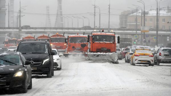 Колонна снегоуборочных машин чистит во время снегопада Садовое кольцо в Москве