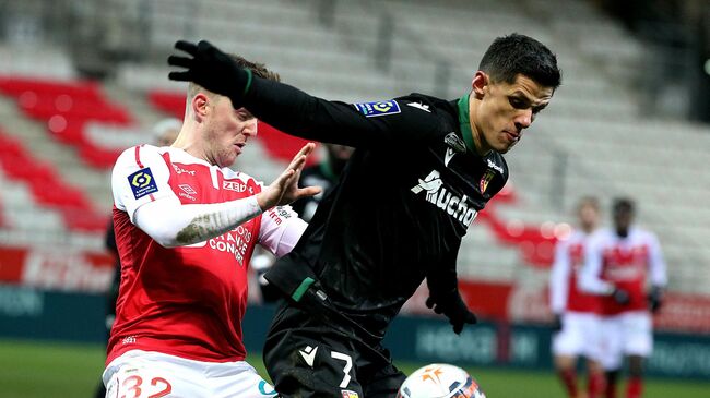 Lens' forward Florian Sotoca (R) fights for the ball with Reims' defender Thomas Foket (L) during the French L1 football match between Reims and Lens on February 13, 2021 at Auguste-Delaune Stadium in Reims. (Photo by FRANCOIS NASCIMBENI / AFP)