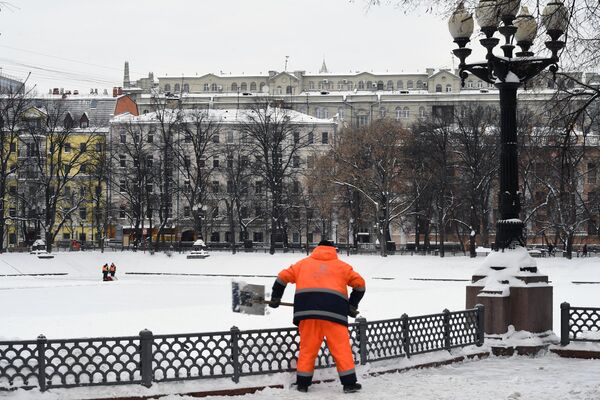 Сотрудник коммунальной службы убирает снег на Патриарших прудах в Москве