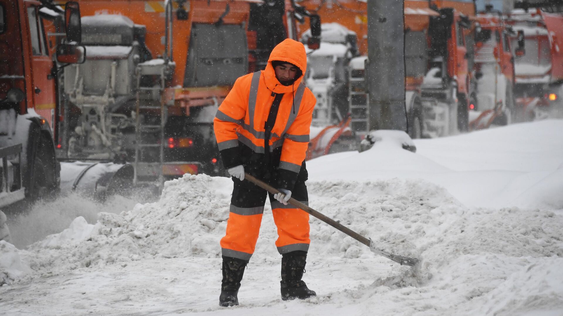Сотрудник коммунальной службы убирает снег на улице в Москве во время снегопада. - РИА Новости, 1920, 15.02.2021