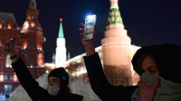 Участники флешмоба с включенными фонариками в Москве