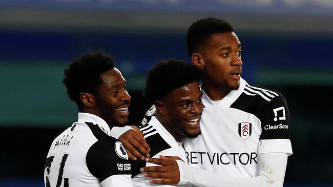 Fulham's Nigerian defender Ola Aina (L) and Fulham's English defender Tosin Adarabioyo (R) congratulate Fulham's Nigerian striker Josh Maja as he celebrates scoring his team's second goal during the English Premier League football match between Everton and Fulham at Goodison Park in Liverpool, north west England on February 14, 2021. (Photo by JASON CAIRNDUFF / POOL / AFP) / RESTRICTED TO EDITORIAL USE. No use with unauthorized audio, video, data, fixture lists, club/league logos or 'live' services. Online in-match use limited to 120 images. An additional 40 images may be used in extra time. No video emulation. Social media in-match use limited to 120 images. An additional 40 images may be used in extra time. No use in betting publications, games or single club/league/player publications. / 