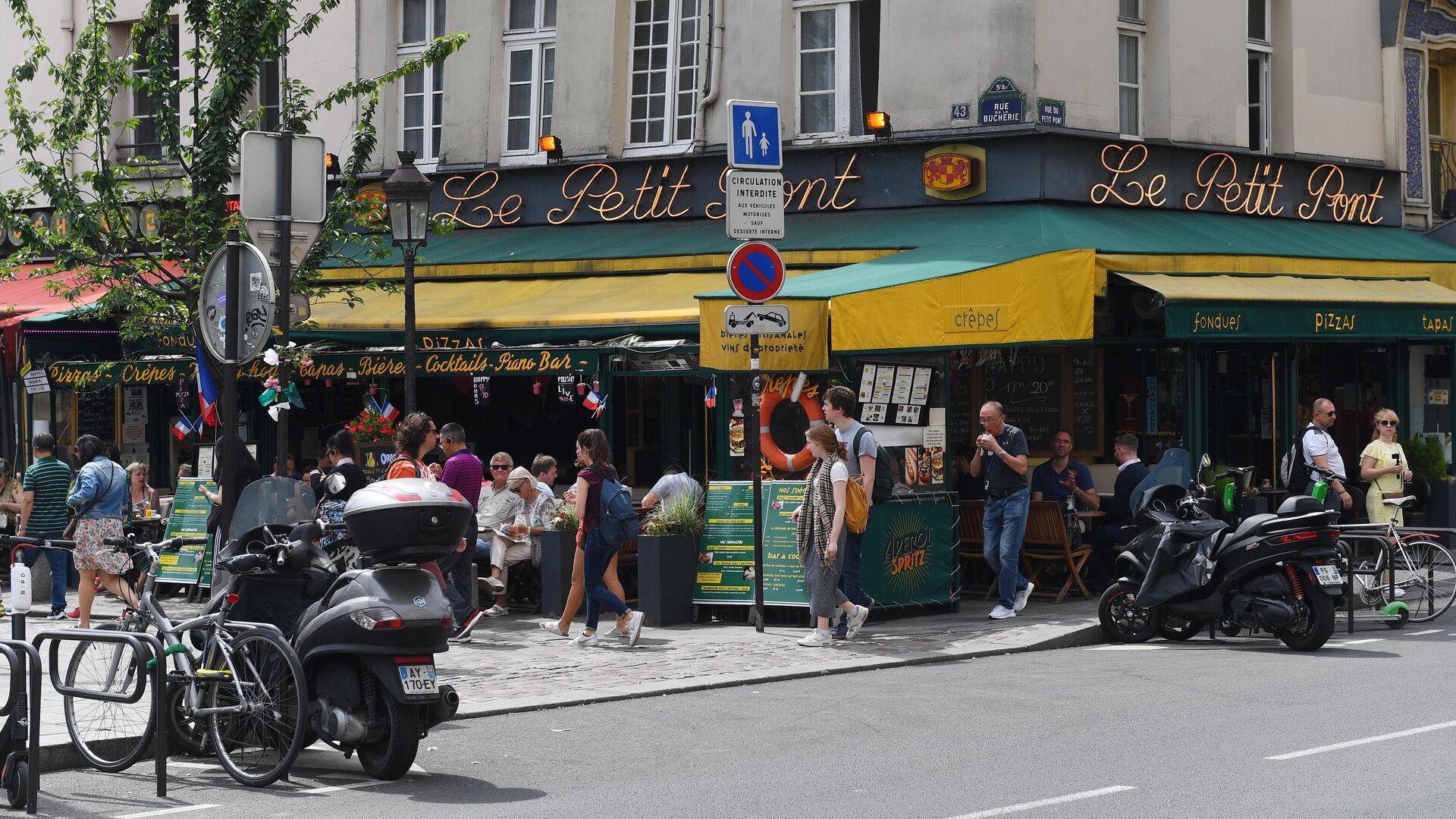 Горожане и туристы на улице Rue du Petit Pont рядом с пабом Cafe Le Petit Pont в Париже - РИА Новости, 1920, 26.07.2022