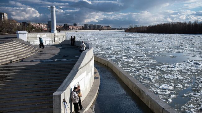 Прохожие на набережной во время ледохода на реке Иртыш в Омске