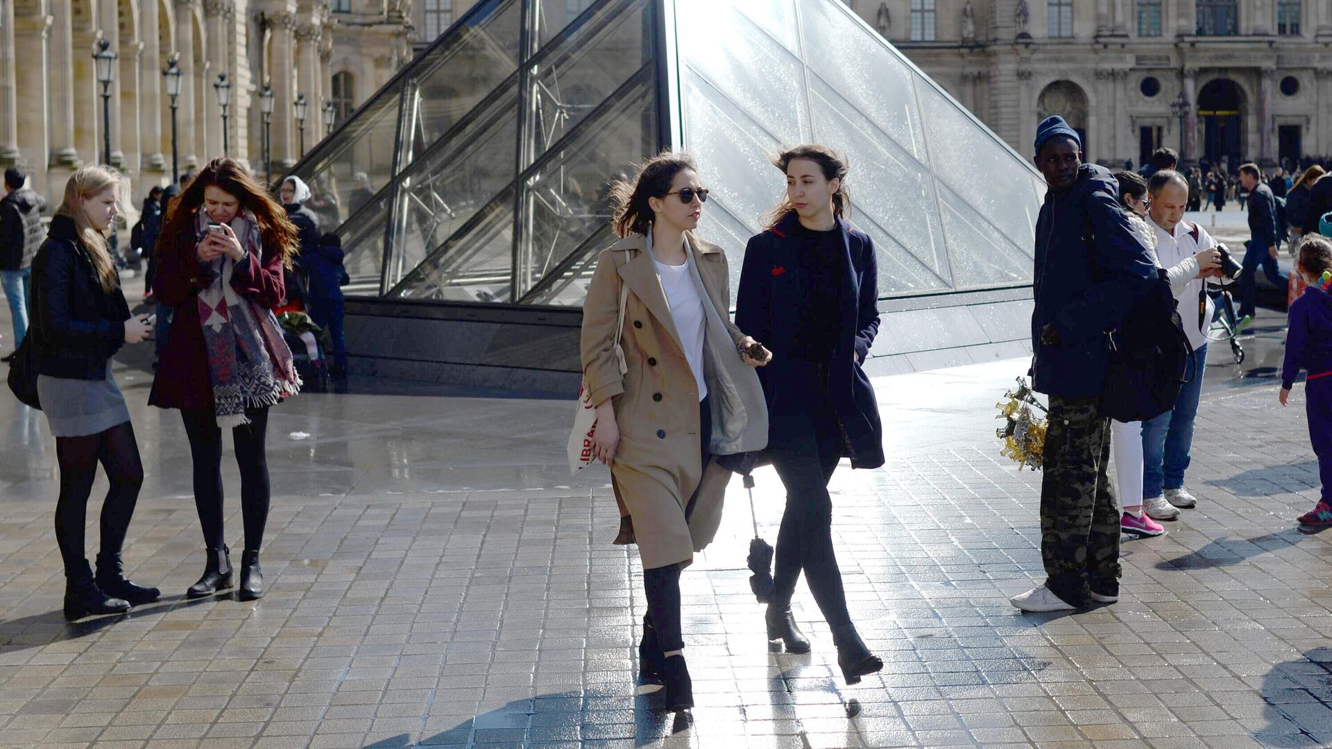 Девушки у стеклянной пирамиды Лувра во дворе Наполеона в Париже - РИА Новости, 1920, 15.01.2024
