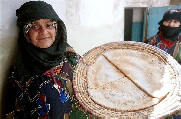 Йеменская женщина показывает традиционные йеменские блины - лахох