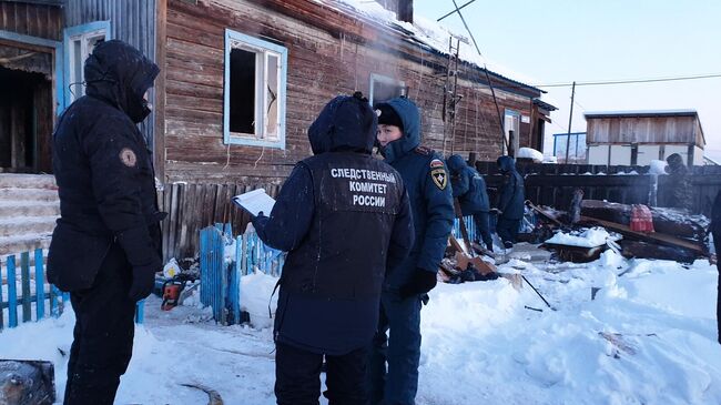 Сотрудники правоохранительных органов на месте пожара в селе Маган