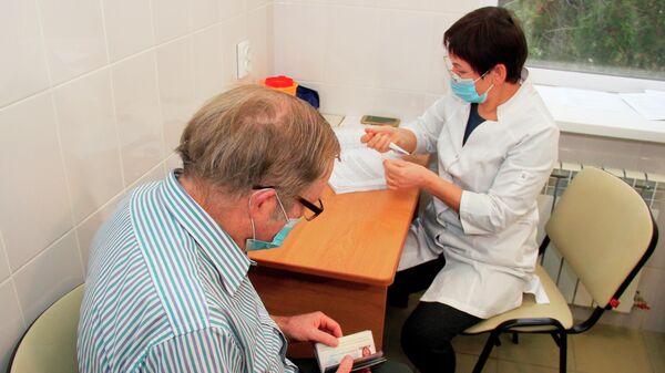 Гражданин США Брюс Уотс Бевен оформляет документы для вакцинации от коронавируса российской вакциной Спутник V (Гам-КОВИД-Вак) в поликлинике в Евпатории