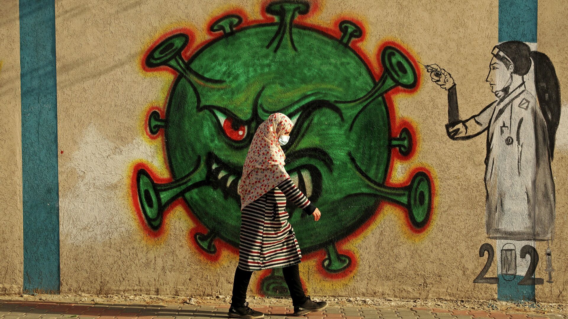 Женщина проходит мимо граффити, посвященного коронавиурсу, в Газе - РИА Новости, 1920, 16.02.2021