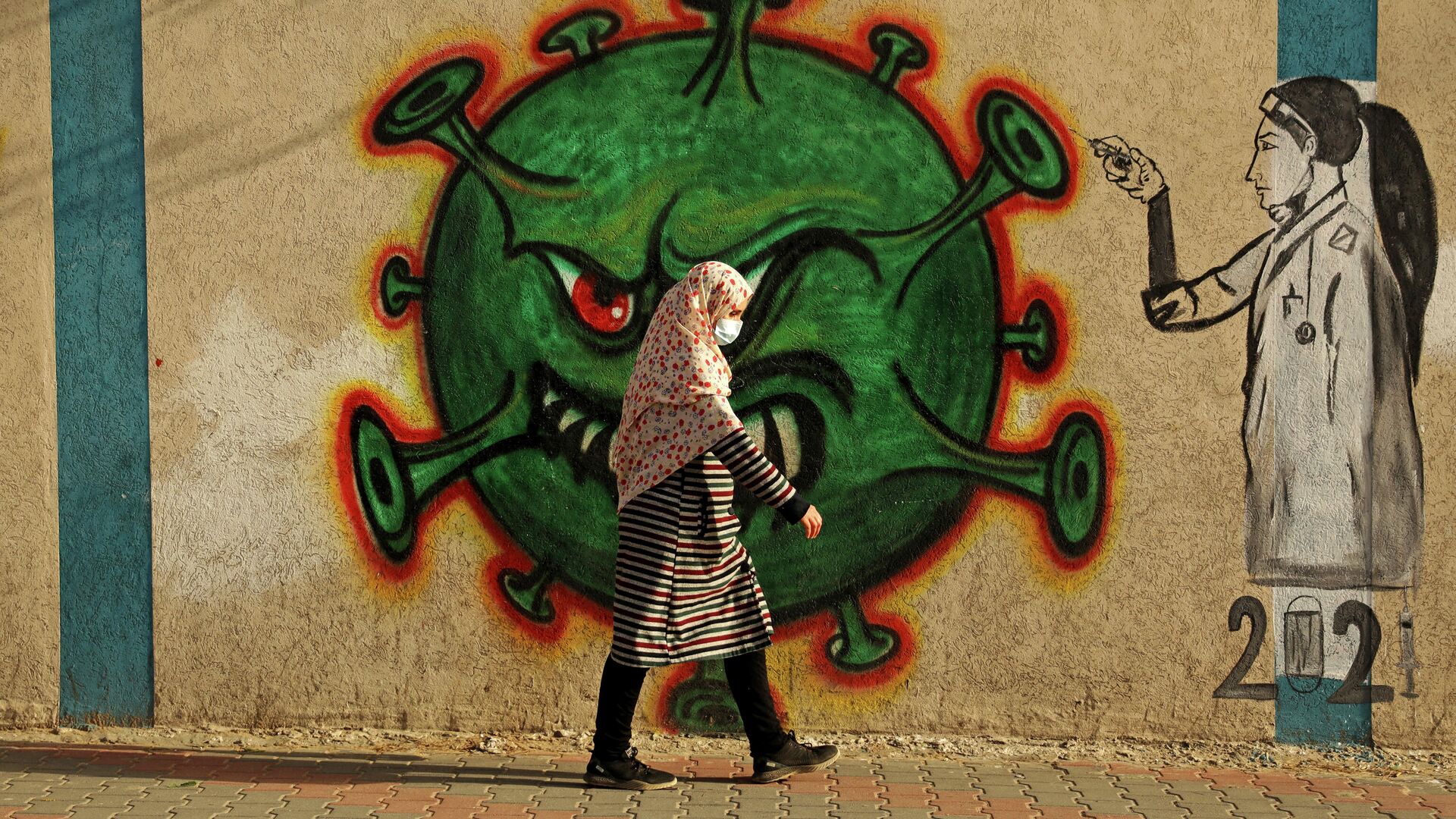 Женщина проходит мимо граффити, посвященного коронавиурсу, в Газе - РИА Новости, 1920, 16.02.2021