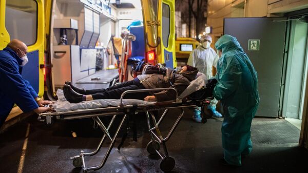Медицинские работники доставляют пациента в приемное отделение госпиталя COVID-19 в городской клинической больнице № 52 в Москве