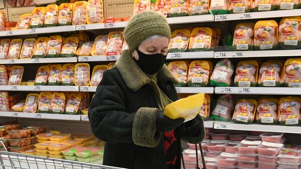 Покупательница выбирает курицу в мясном отделе гипермаркета Ашан в Москве