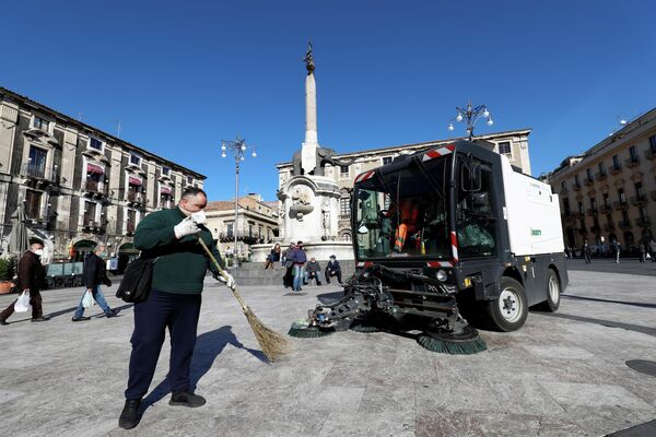Уборка площади после извержения вулкана Этна в Катании, Италия. 17 февраля 2021 года